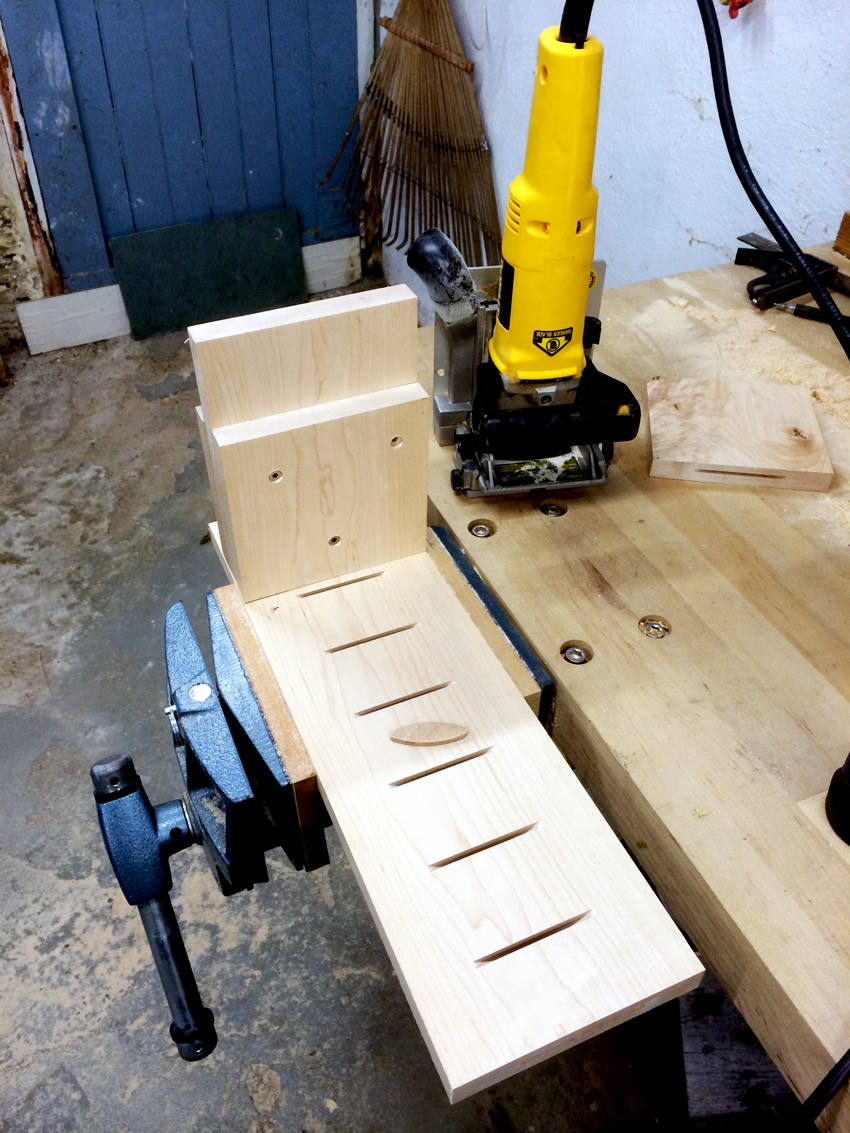 a biscuit joiner next to a board with slots cut in it